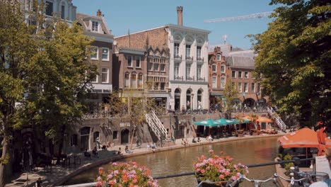 Oudegracht-canal-crowded-by-tourists-in-Utrecht-Netherlands,-tilt-down
