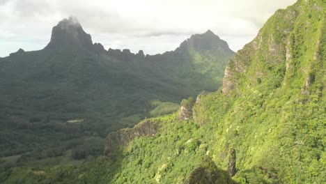 Aerial-parallax-shot-revealing-a-stunning-mountain-range-in-Mo'orea-island,-French-Polynesia
