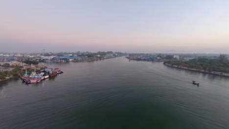 Fishing-Boats-Docked-On-The-Lakeshore-In-Rayong-Port,-Thailand-On-A-Sunrise---Aerial-Shot