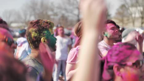 Focusing-on-man's-face-while-dancing-in-crowds-at-Holi-festival,-Slow-motion