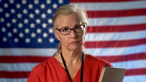 Porträt-Einer-Krankenschwester-Vor-Einer-Unscharfen-US-Flagge,-Die-Enttäuschung-Und-Traurigkeit-Zeigt