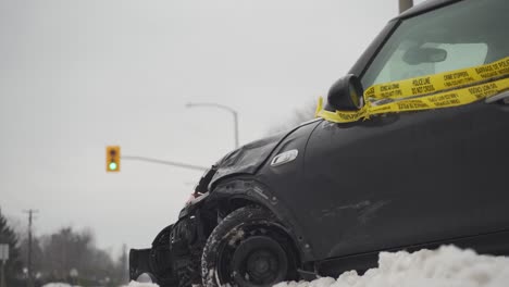 Crashed-vehicle-beside-a-stop-light-on-a-snowy-raod