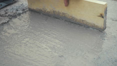 Working-flattening-freshly-poured-cement-CLOSE-UP