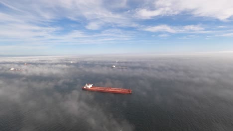 LONG-BEACH,-CA---Circa-September,-2019---An-early-morning-foggy-aerial-view-of-large-cargo-ships-docked-near-Long-Beach,-California
