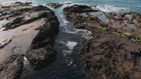 Slow-tilt-reveals-the-relaxing-flow-of-the-tide-pools-on-the-shore-of-Porto-das-Salemas
