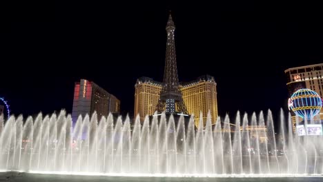 Bellagio-Fountain-and-Paris-Hotel-and-Casino,-Las-Vegas-at-Night,-Nevada-USA