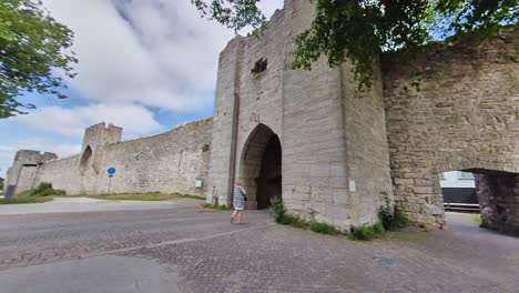 People-waking-through-the-South-Gate,-Visby-City-Wall,-Gotland,-Sweden
