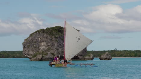 People-sitting-on-traditional-Kanak-pirogue-boat-on-Upi-Bay,-New-Caledonia