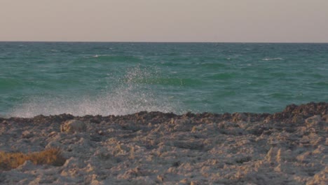 Slowmotion-shot-of-the-adriatic-sea-with-waves-crashing-on-the-rocks-and-beatiful-colored-sky,-Turquoise-water-in-South-Italy