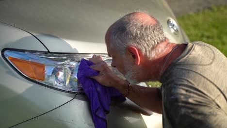 Man-washing-headlight-on-car-sprays-water-in-his-face-by-accident-in-slow-motion