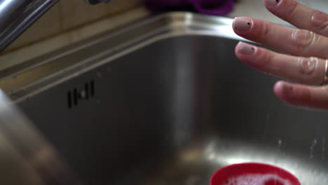 Close-up-of-woman-washing-her-hands-with-liquid-soap-over-a-house-sink