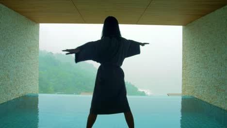 The-soft-and-blur-focus-of-Asia-women-standing-and-exercise-on-the-private-poolside-in-the-resort-on-vacation-time