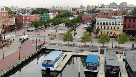 Historic-Fells-Point,-water-taxi-line-up-by-empty-restaurants,-bars,-stores,-Baltimore-Inner-Harbor-MD-USA
