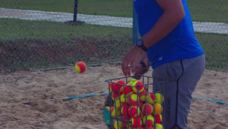 Isolierte-Ansicht-Eines-Mannes,-Der-Beim-Beach-Tennis-Training-Bälle-über-Das-Netz-Schlägt