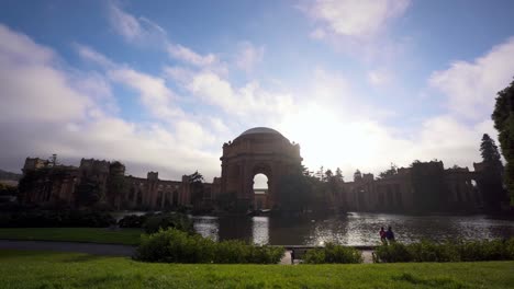 The-Palace-of-Fine-Arts,-clouds-moving-fast-and-people-walking-by-the-lake