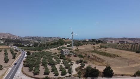Aerial-view:-wind-turbine-on-Mediterranean-farm-hilltop,-Europe