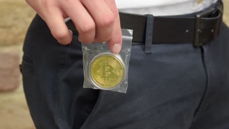 Junger-Geschäftsmann-Zieht-Einen-Goldenen-Bitcoin-In-Einer-Plastiktüte-Aus-Seiner-Tasche
