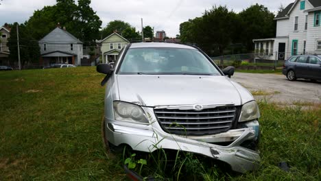 Stolen-car,-vandalized,-and-wrecked-left-abandoned-in-an-empty,-grassy-lot
