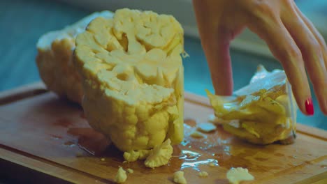 Close-Up-of-Female-Hands-Cutting-in-Pieces-White-Cauliflower-With-Kitchens-Knife-Full-Frame
