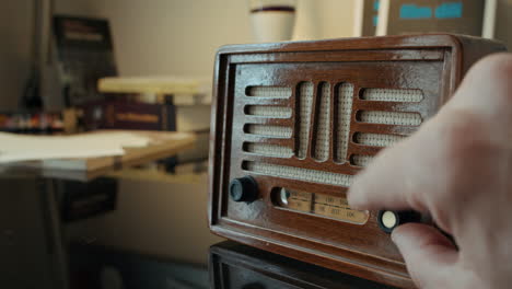 Close-up-of-Old-Wooden-Vintage-Radio-and-Hand-Tuning-Radio-Channels-with-Adjustment-Knob