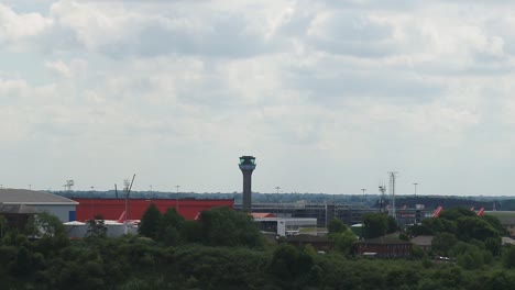 Rising-aerial-establishing-view-of-Luton-Airports-Air-Traffic-Control-tower-and-grounded-aircraft-during-the-coronavirus-pandemic
