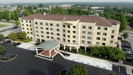 Push-in-wide-angle-aerial-establishing-shot,-new-Courtyard-by-Marriott-hotel-motel-during-summer-day