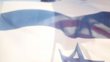 Flag-of-Israel-Flies-in-Slow-Motion,-with-American-Flag-Lurking-in-Background,-Slow-Motion