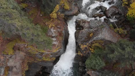 Ein-Malerischer-Wasserfall-Stürzt-Durch-Einen-Von-Pinien-Umgebenen-Felsigen-Berg-In-Alaska