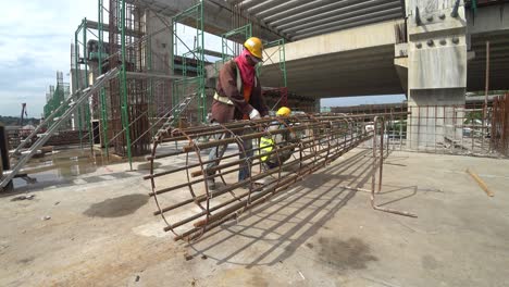 Trabajadores-De-La-Construcción-Instalando---Fabricando-Encofrados-De-Madera-Y-Barras-De-Refuerzo-En-El-Sitio-De-Construcción
