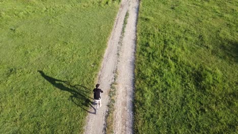 Luftaufnahmen-Eines-Mannes,-Der-An-Einem-Sonnigen-Sommertag-Sein-Fahrrad-Auf-Einer-Landstraße-Reitet