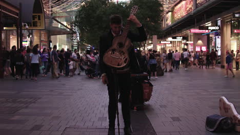 Patreons-Gehen-Während-Der-Weihnachtsferien-Durch-Die-Straßen-Der-Innenstadt-Von-Sydney,-Australien,-Während-Ein-Mann-Für-Geld-Gitarre-Spielt