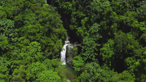 Water-Crashes-over-Small-Cliff-Surrounded-by-Beautiful-Lush-Green-Trees-and-Shrubs,-Saltos-Jima-Waterfall,-Aerial-Drone