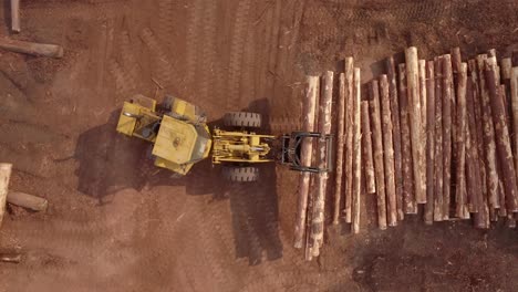 4K-Aerial-Top-Down-of-Yellow-Timber-Front-End-Loader-Vehicle-With-Claws-Moving-Logs