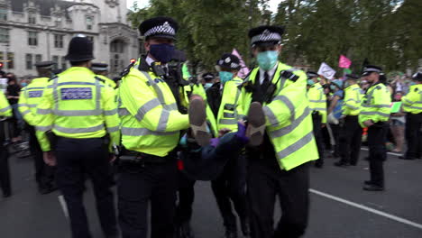 London-Metropolitan-officers-carry-detained-Extinction-Rebellion-climate-change-protestors-though-police-cordon-lines-during-protests-outside-parliament-in-Westminster-during-the-Coronavirus-pandemic