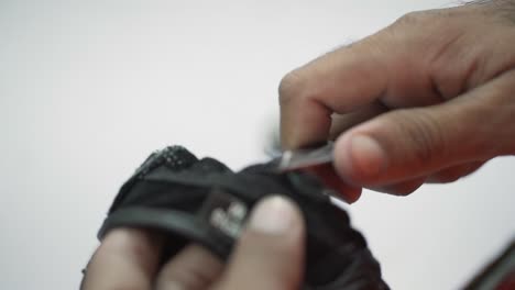 Closeup-Of-Worker-Cutting-Cotton-Thread-During-Manufacturing-Leather-Gloves-Product