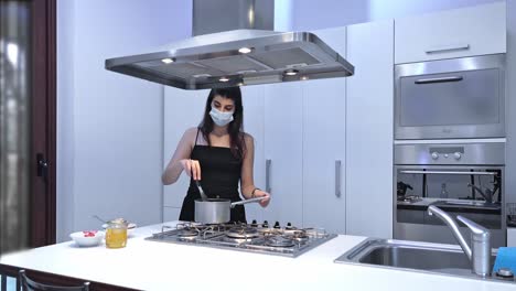 Young-woman-at-home-preparing-food-with-protective-mask