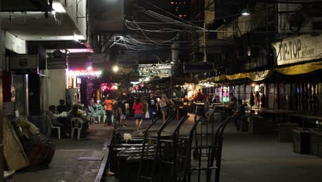 Una-Pareja-De-Turistas-Caucásicos-Caminando-Por-Un-Mercado-Nocturno-Vacío-De-Patpong-En-Bangkok,-Tailandia