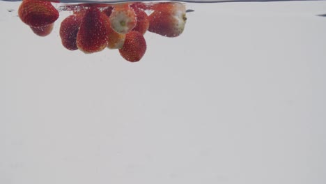 Ganze-Erdbeeren,-Die-Im-Wasser-Planschen