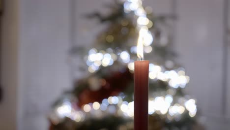 Vela-Roja-Frente-A-Un-árbol-De-Navidad
