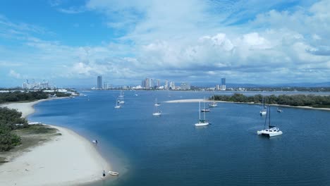 Aerial-view-of-a-safe-boat-harbor-on-a-clear-blue-sky-day-with-a-city-skyline-in-the-distance