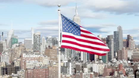 Filmaufnahmen-Aus-Der-Luft-Mit-Der-Wehenden-US-Flagge-Im-Wind-Und-Dem-Empire-State-Building-Im-Hintergrund