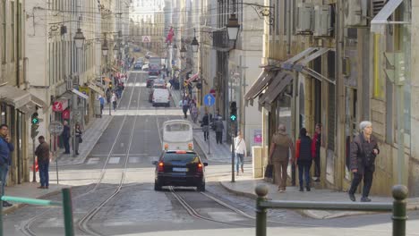 Ein-Blick-Auf-Die-Lissabonner-Straßenbahn,-Die-Sich-Auf-Ihrem-Gleis-Bewegt,-Wo-Viele-Touristen-Die-Altstadt-Von-Portugal-Besuchen
