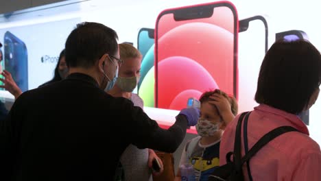 A-customer-has-his-temperature-checked-before-entering-an-Apple-store-during-the-launch-day-of-the-new-iPhone-12-and-iPhone-12-Pro-phones