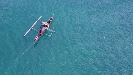 overhead-shot-of-a-man-fishing-off-a-small-fishing-dhow-in-the-Indian-Ocean-near-Madagascar