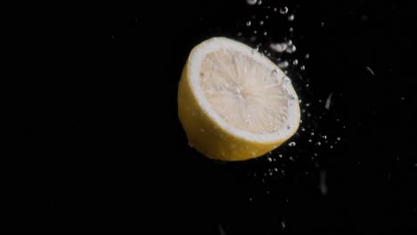 Lemon-Falling-into-Water-Super-Slowmotion,-Black-Background,-lots-of-Air-Bubbles,-4k240fps