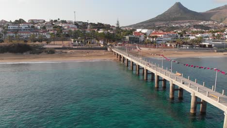 Flying-past-a-walkway-leading-into-the-ocean-with-the-town-buildings-of-Porto-Santo-in-view