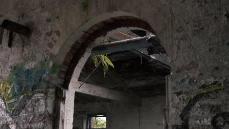 View-of-derelict-building-through-archway-medium-panning-shot