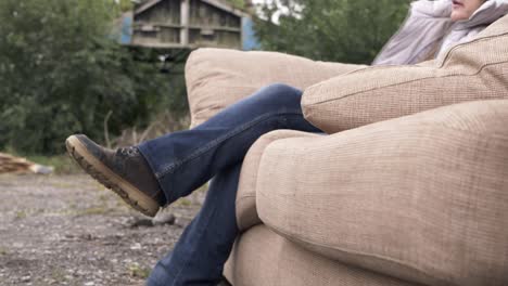 Woman-relaxing-on-sofa-in-junkyard-medium-shot