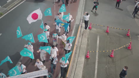 Manifestantes-Con-Pancartas-Y-Turkestán-Oriental-Y-Bandera-Japonesa-Marchando-En-Las-Calles-De-Tokio-Por-La-Noche-En-Japón