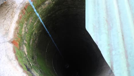 Asian-Woman-Getting-Water-From-Deep-Well---High-Angle-Shot